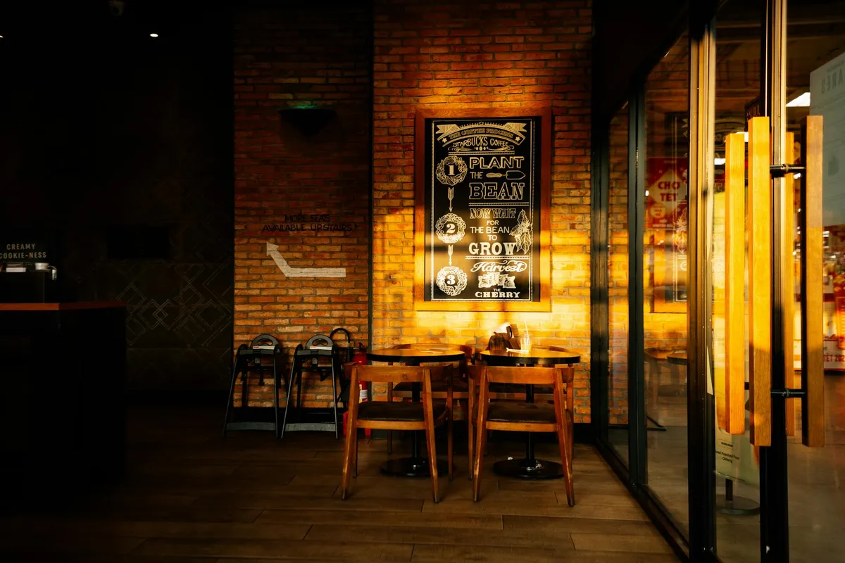 A cozy modern café with wood tables and warm natural lighting
