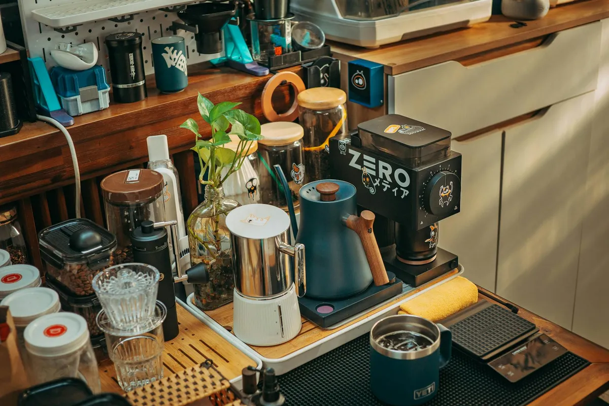 A modern coffee setup with grinder and kettle on a kitchen counter