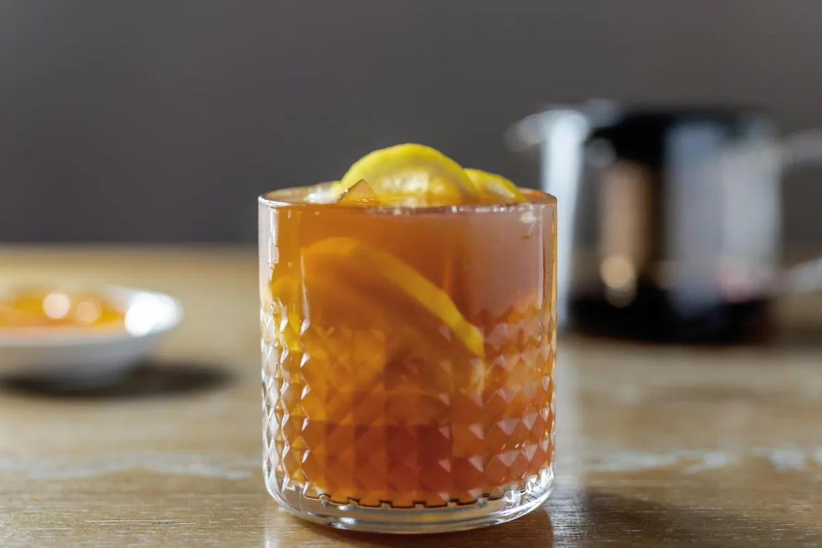 A glass of espresso tonic with ice and citrus